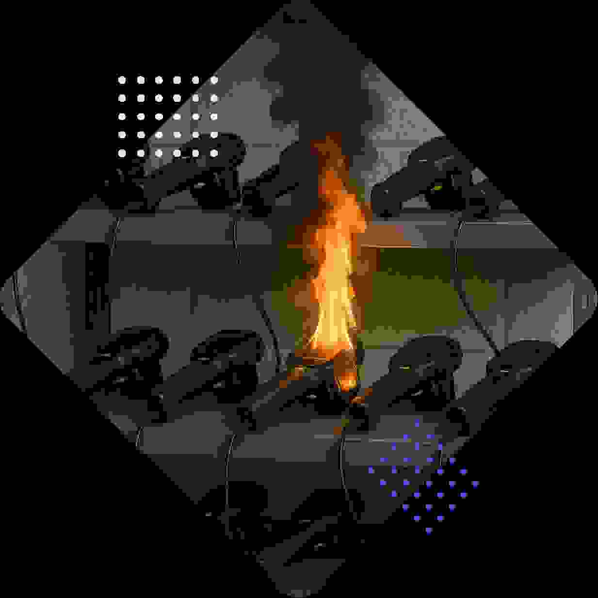 A shelf of black devices with one emitting flames and smoke.