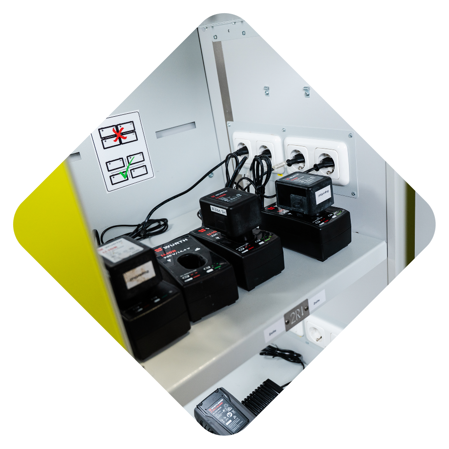 Battery charging station with multiple battery chargers and power outlets.