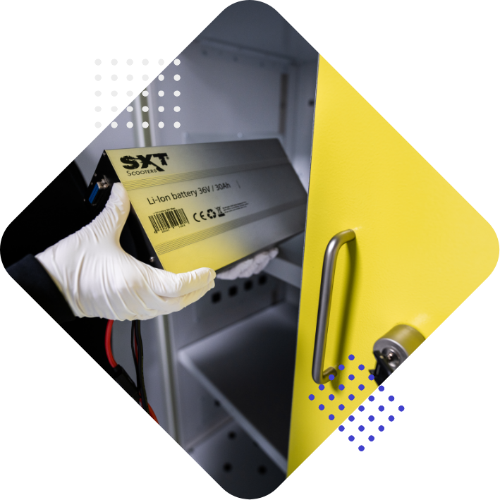 Bild eines Technikers, der eine Lithium-Ionen-Batterie in einen gelben Schrank einsetzt.