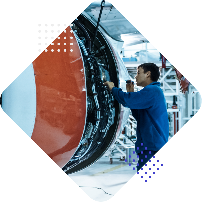 Ein Techniker arbeitet an einem Flugzeugtriebwerk in einer Werkstatt.