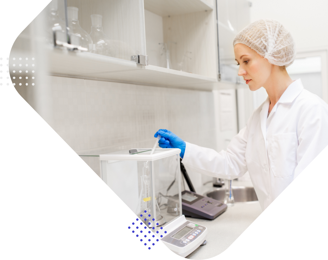 Laborantin in weißem Laborkittel misst mit einer Pipette in einem Labor.